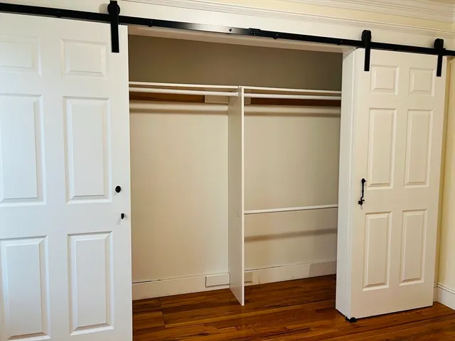 a view of walk in closet with wooden floor