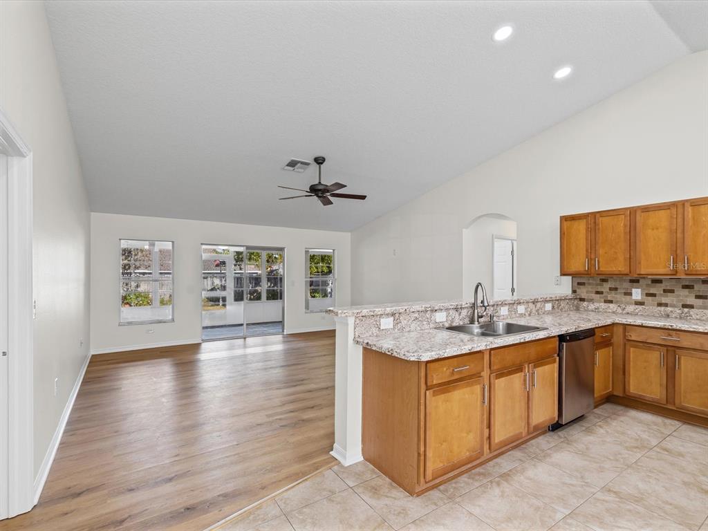 11217 Kangley Lane Spring Hill, FL 34608 - Photo 15 of 43 a view of a kitchen with kitchen island a sink stainless steel appliances and cabinets
