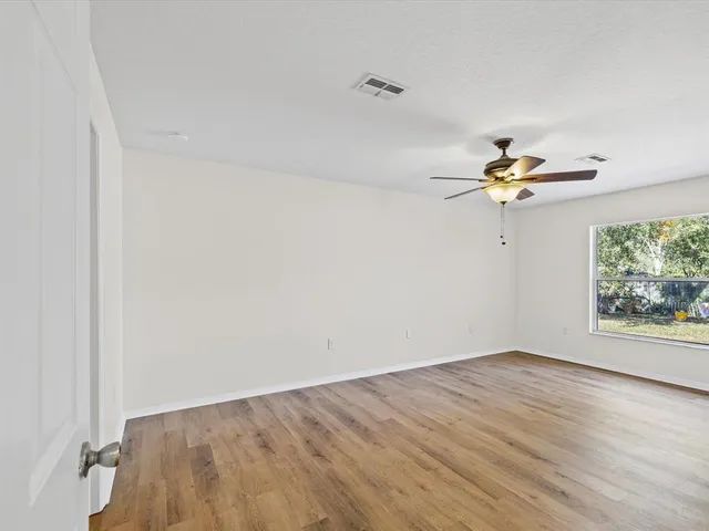 wooden floor in an empty room with a window