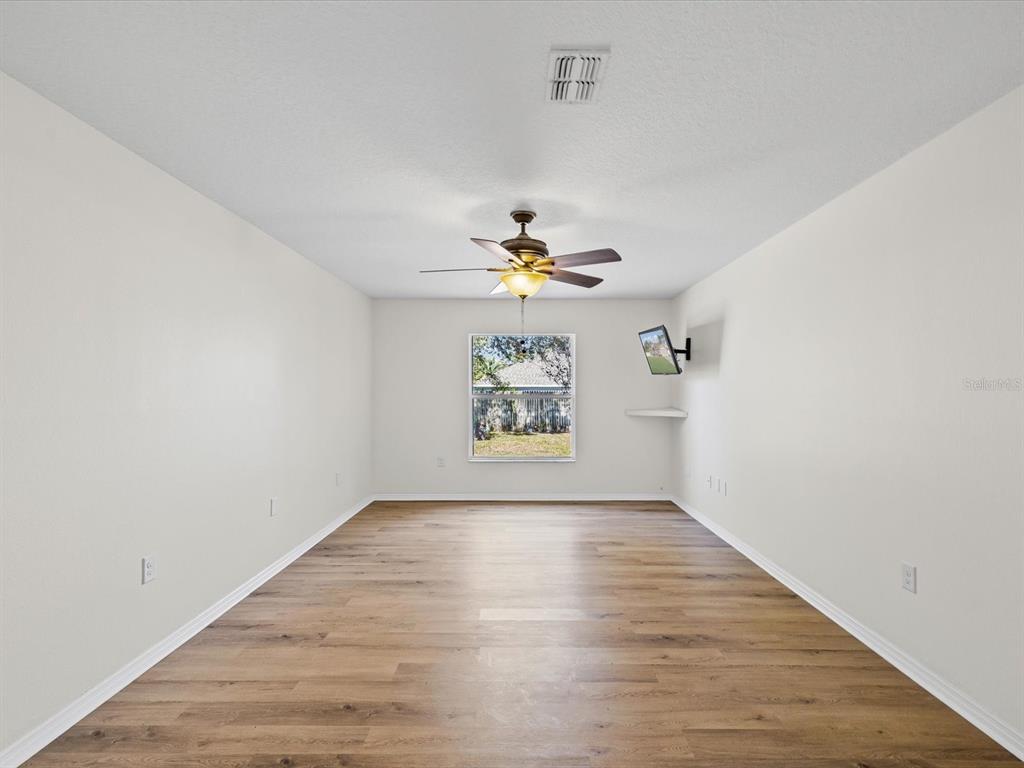 11217 Kangley Lane Spring Hill, FL 34608 - Photo 19 of 43 wooden floor in an empty room with a window