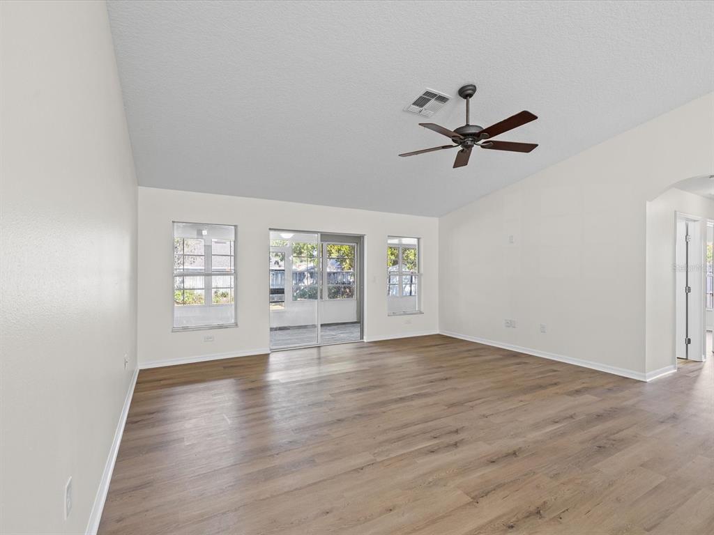 11217 Kangley Lane Spring Hill, FL 34608 - Photo 3 of 43 an empty room with wooden floor and windows