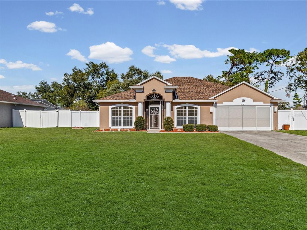 11217 Kangley Lane Spring Hill, FL 34608 - Photo 41 of 43 a view of a yard in front of a house with a garden