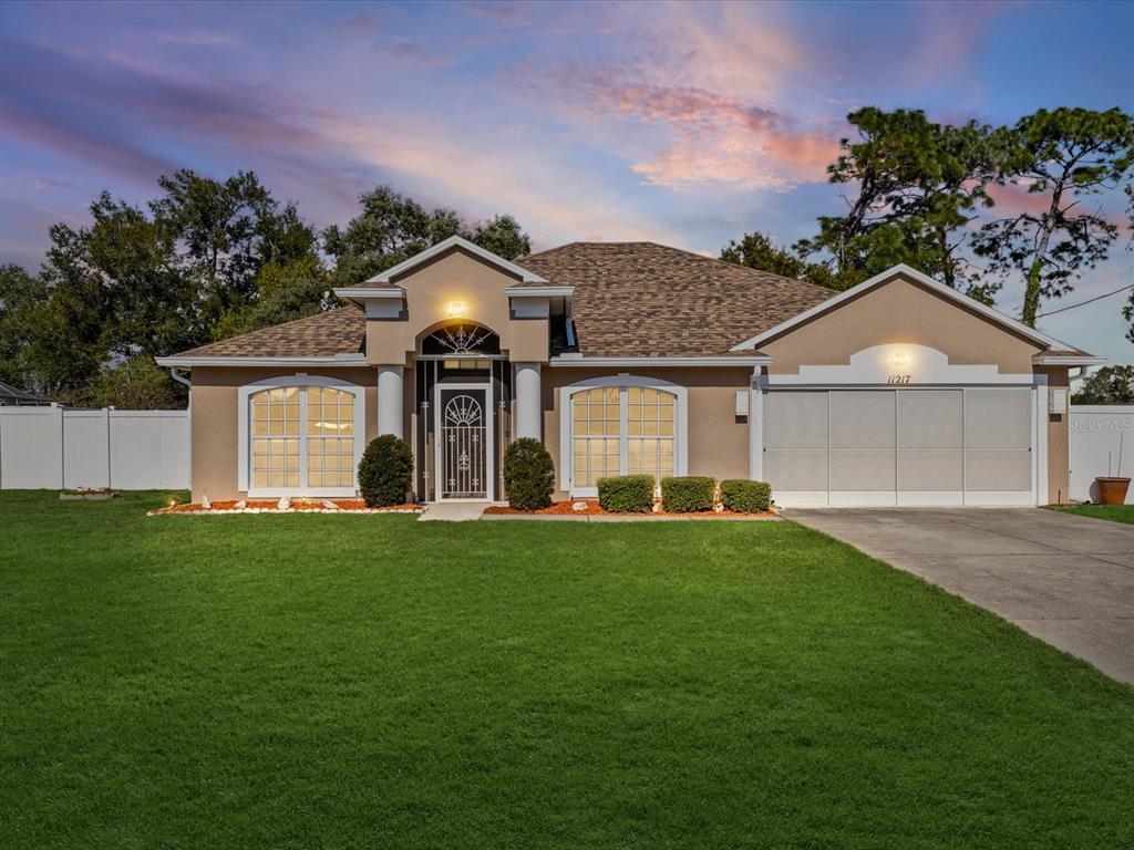 11217 Kangley Lane Spring Hill, FL 34608 - Photo 6 of 43 a front view of a house with a garden and yard