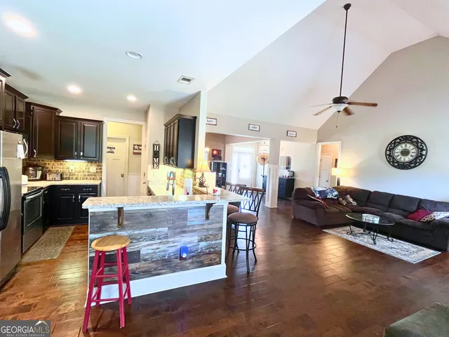 a living room with kitchen appliances and a dining table