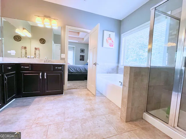 a spacious bathroom with a bathtub sink and mirror