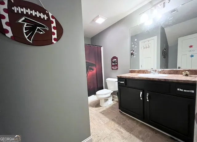 a bathroom with a sink vanity and toilet