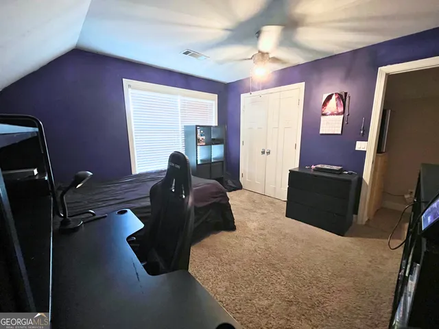 a bedroom with a bed and a flat tv screen on dresser