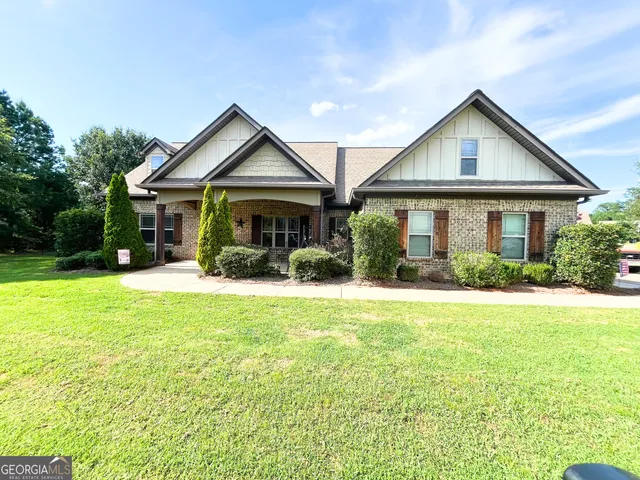 a view of a house with a yard and potted plants