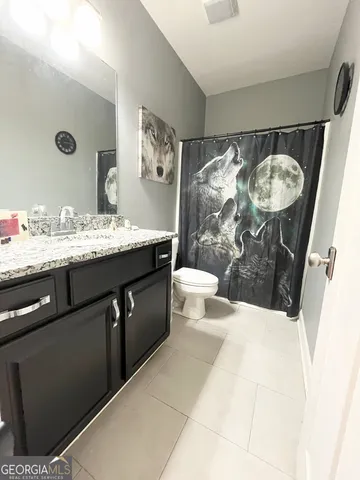 a bathroom with a sink mirror vanity and toilet