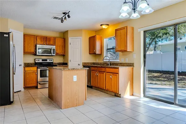 a kitchen with stainless steel appliances granite countertop a stove a sink and a refrigerator