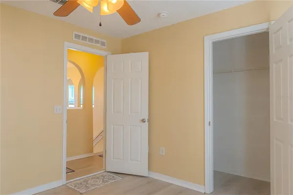 a view of empty room with window and chandelier fan