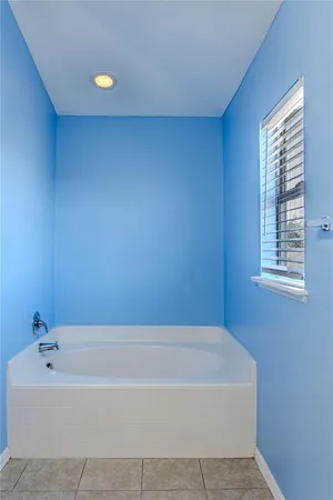 a white bath tub sitting in a bathroom next to a window