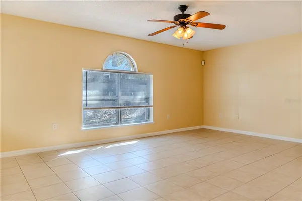 a view of a room with a chandelier fan and window