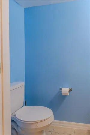 a white toilet sitting next to a white wall