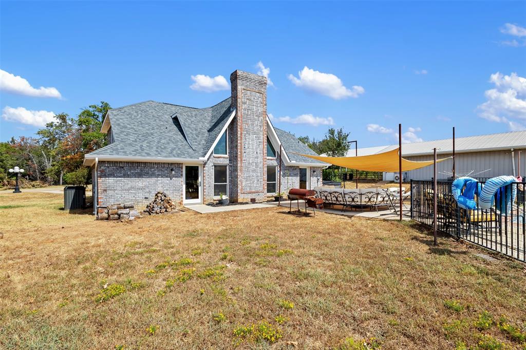 668 Cleve Cole Road Denison, TX 75021 - Photo 24 of 38 Brick exterior with a prominent chimney and gabled roofline