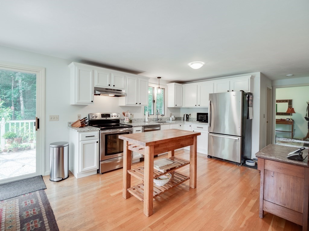 4 Crabtree Lane Shirley, MA 01464 - Photo 9 of 36 a kitchen with granite countertop a refrigerator stove a sink dishwasher and wooden cabinets with wooden floor