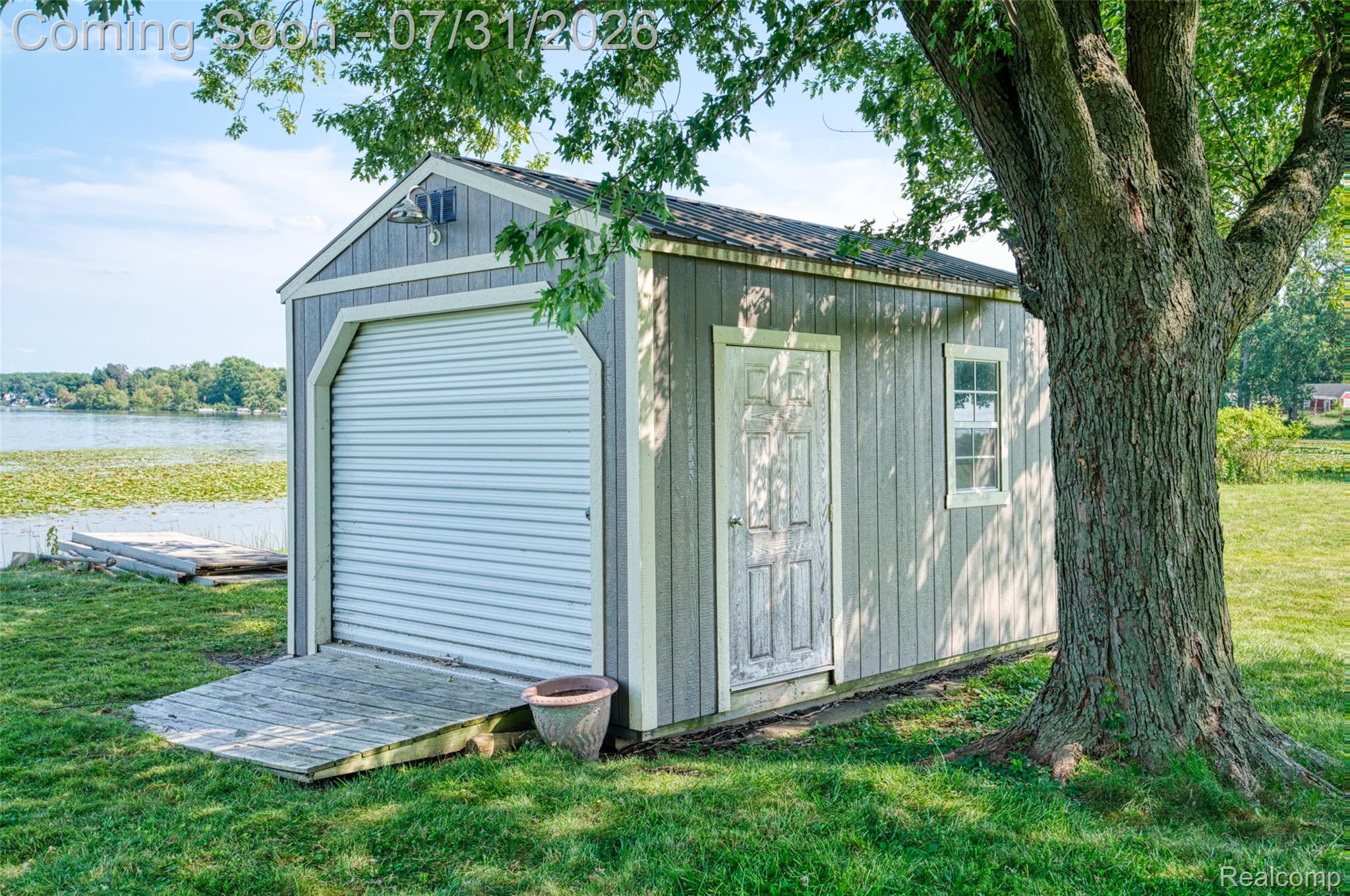 5269 Reno Road Manchester, MI 48158 - Photo 25 of 64 Waterfront storage shed featuring a rolling garage door and a side entry door