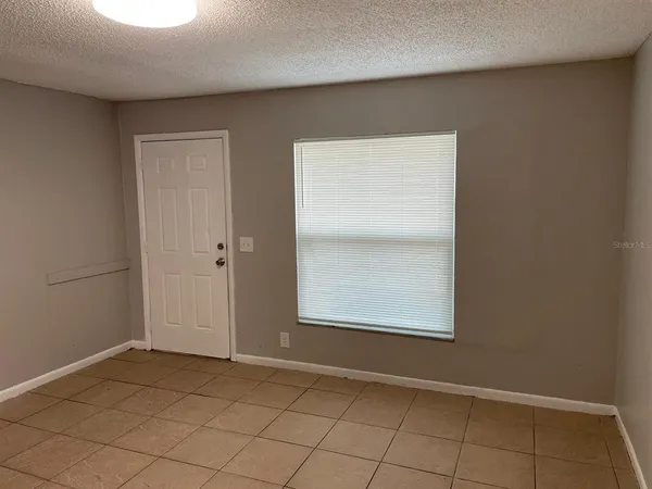 a view of a kitchen with a sink and an empty room