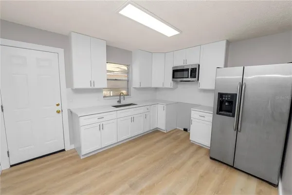 a kitchen with a refrigerator sink and cabinets