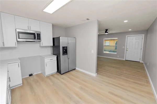 an empty room with windows and cabinet