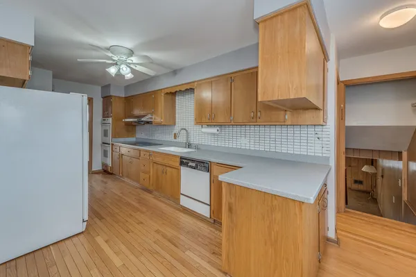 a kitchen with stainless steel appliances granite countertop a sink a stove cabinets and wooden floor