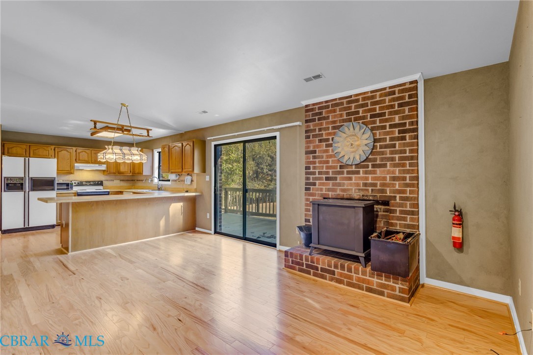 278 Regent Road Hartfield, VA 23071 - Photo 49 of 49 Kitchen featuring light countertops, white fridge with ice dispenser, decorative light fixtures, open floor plan, and a peninsula