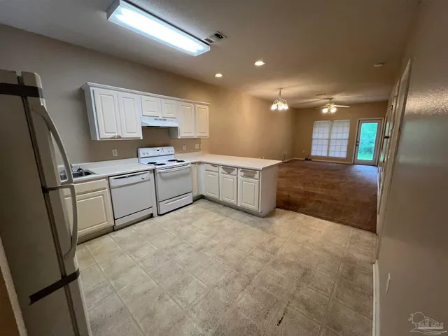 a kitchen with a refrigerator sink and cabinets