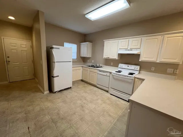 a view of a kitchen with a sink and a refrigerator