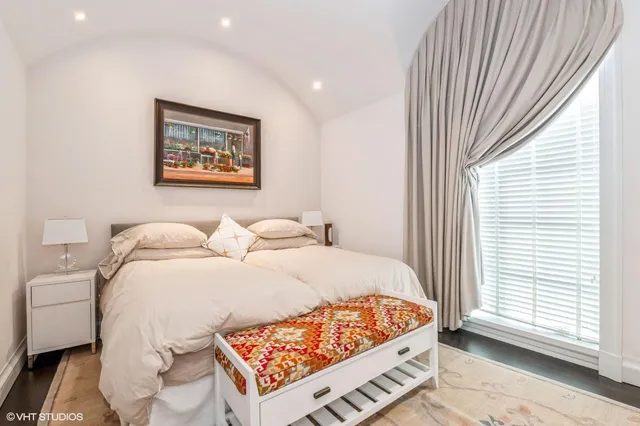 a bed sitting in a bedroom next to a window