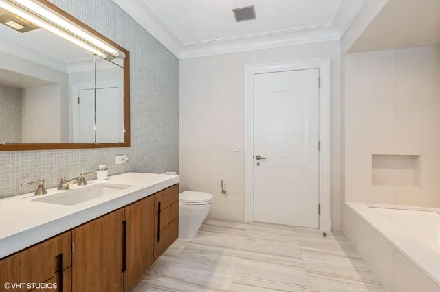 a spacious bathroom with a double vanity sink a mirror and a bathtub