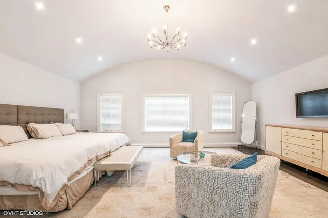 a spacious bedroom with a bed a couch and a flat screen tv