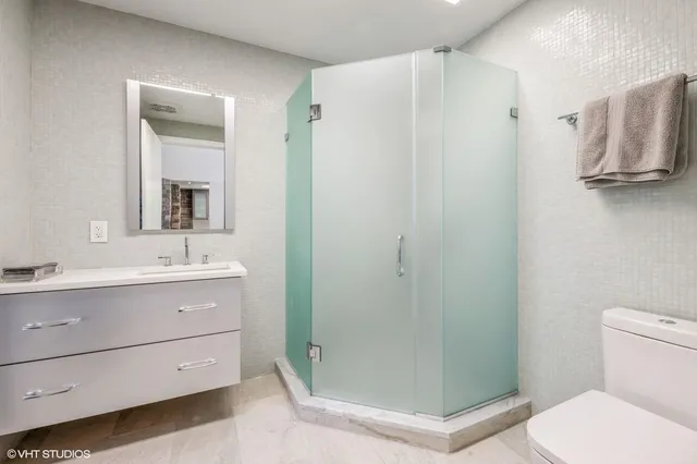 a bathroom with a shower a sink a toilet and mirror