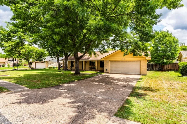 a front view of a house with a yard and trees