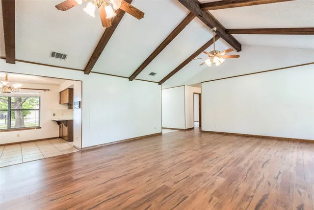 a view of a room with wooden floor and windows
