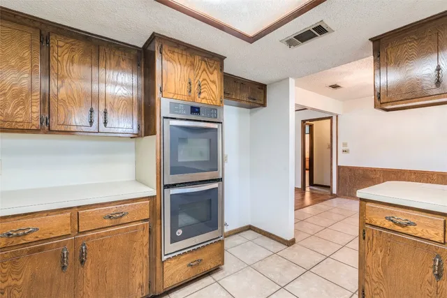 a kitchen with granite countertop stainless steel appliances a stove and a refrigerator