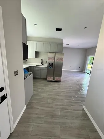 a kitchen with cabinets and wooden floor
