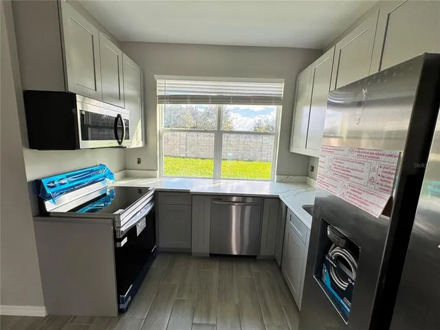 a kitchen with stainless steel appliances granite countertop a sink and a stove