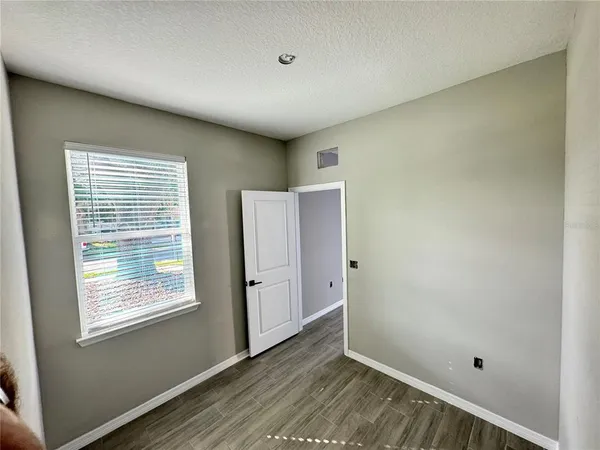 a view of an empty room with closet and window