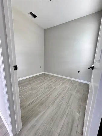 a view of a big room with wooden floor and a window