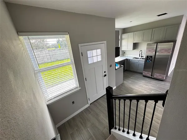 a view of entryway and hall with wooden floor