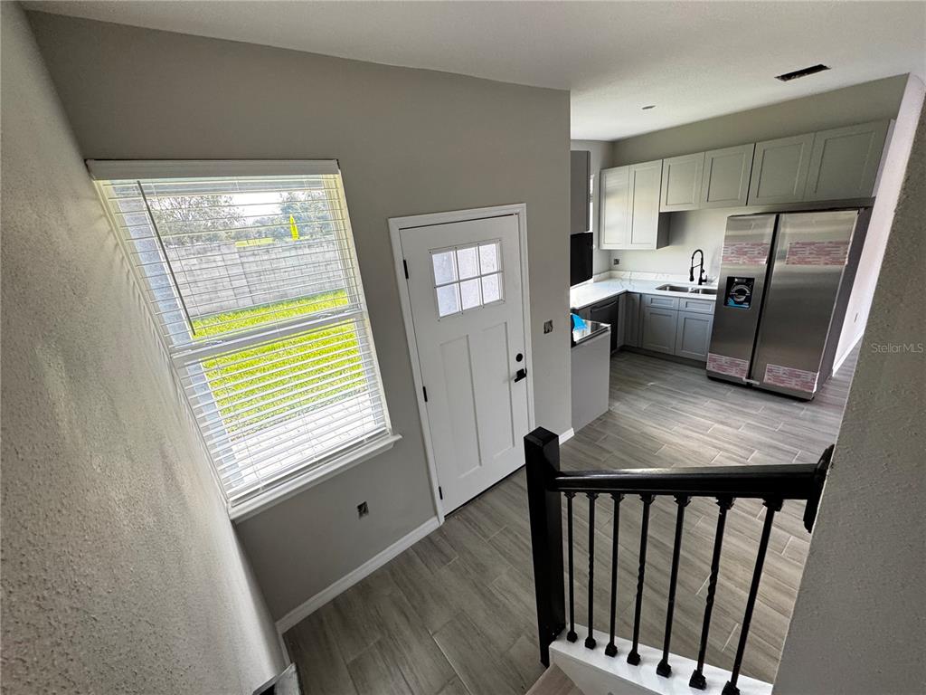 101 Grove Street Orlando, FL 32835 - Photo 23 of 57 a kitchen with refrigerator a window and wooden floor