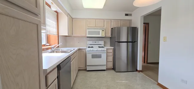 a kitchen with a refrigerator sink and cabinets