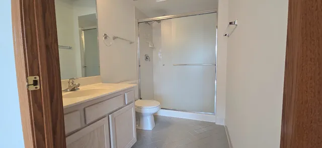 a bathroom with a granite countertop sink toilet and shower