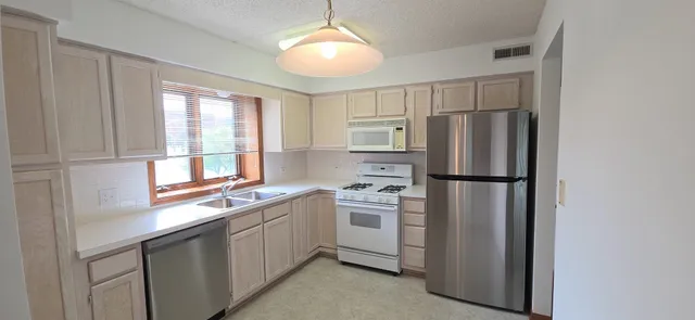 a kitchen with a refrigerator a sink and cabinets