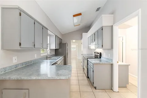 a kitchen with stainless steel appliances granite countertop a sink stove and cabinets