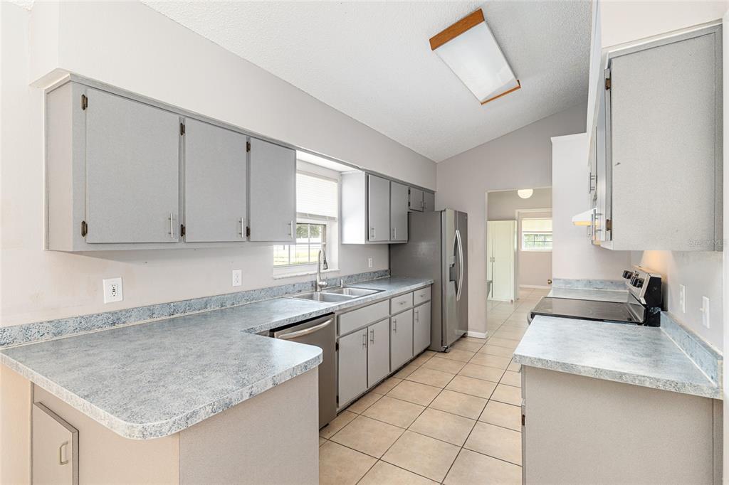 21 Pecan Course Circle Ocala, FL 34472 - Photo 16 of 46 a kitchen with stainless steel appliances granite countertop a sink stove and refrigerator