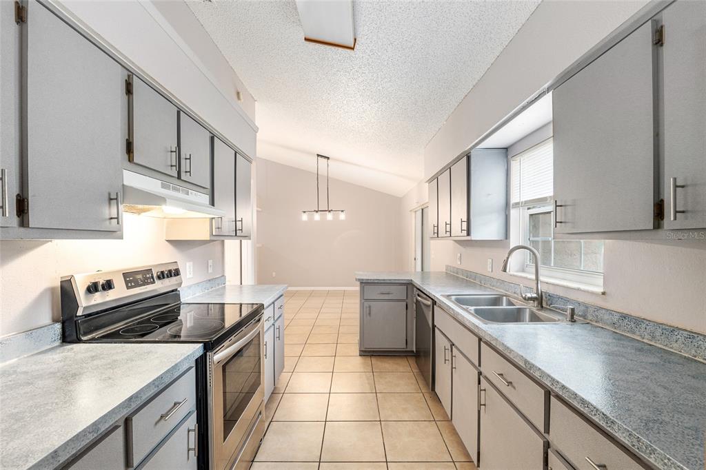 21 Pecan Course Circle Ocala, FL 34472 - Photo 18 of 46 a kitchen with stainless steel appliances granite countertop a sink stove and refrigerator