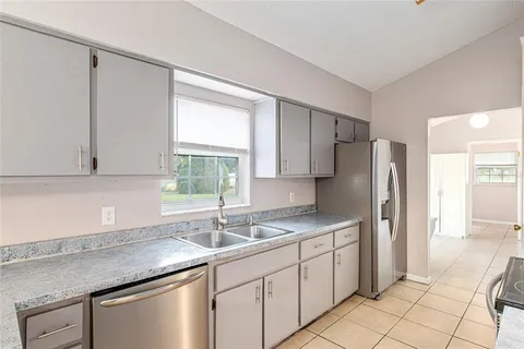a kitchen with a sink a refrigerator and cabinets