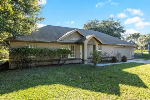 a front view of a house with a garden and yard