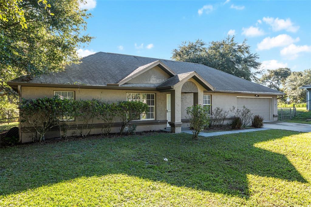 21 Pecan Course Circle Ocala, FL 34472 - Photo 2 of 46 a front view of a house with a garden and yard